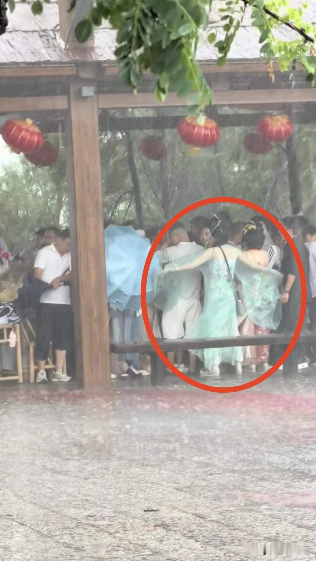 开封万岁山爆火是有原因的！突如其来的一场暴雨，让许多人都到亭子里避雨，这位穿绿色