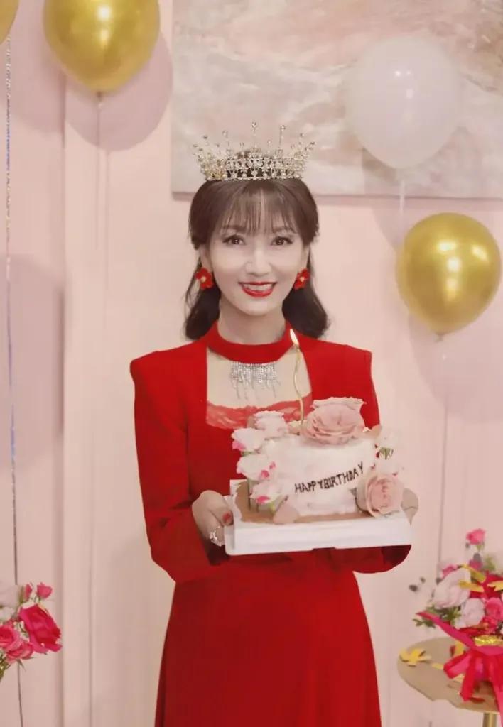 赵雅芝71岁生日，分享庆生照。她身着玫红长裙，笑容满面，手捧粉嫩蛋糕，幸福洋溢。