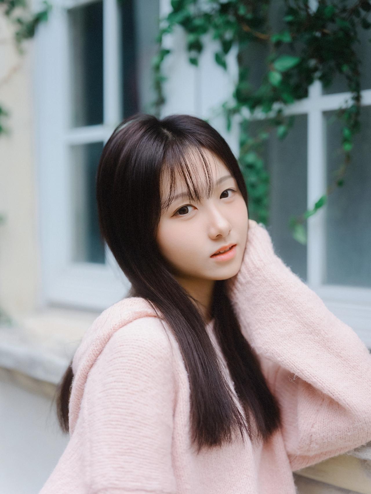 温柔甜美的少女，粉色毛衣与绿植背景相得益彰，尽显青春活力！🌸💕粉色长袖穿搭 