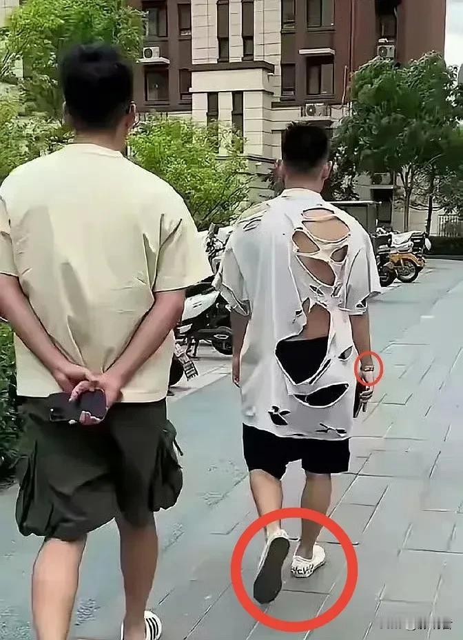 想不明白，男子穿着破烂不堪的短袖，却戴着名贵手表，穿着高档鞋，招摇过市。他是没有