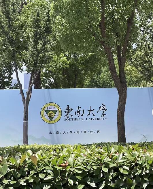 东南大学南通校区的工地围挡，印着东南大学的校徽、校训，以及南通校区的建成效果图。