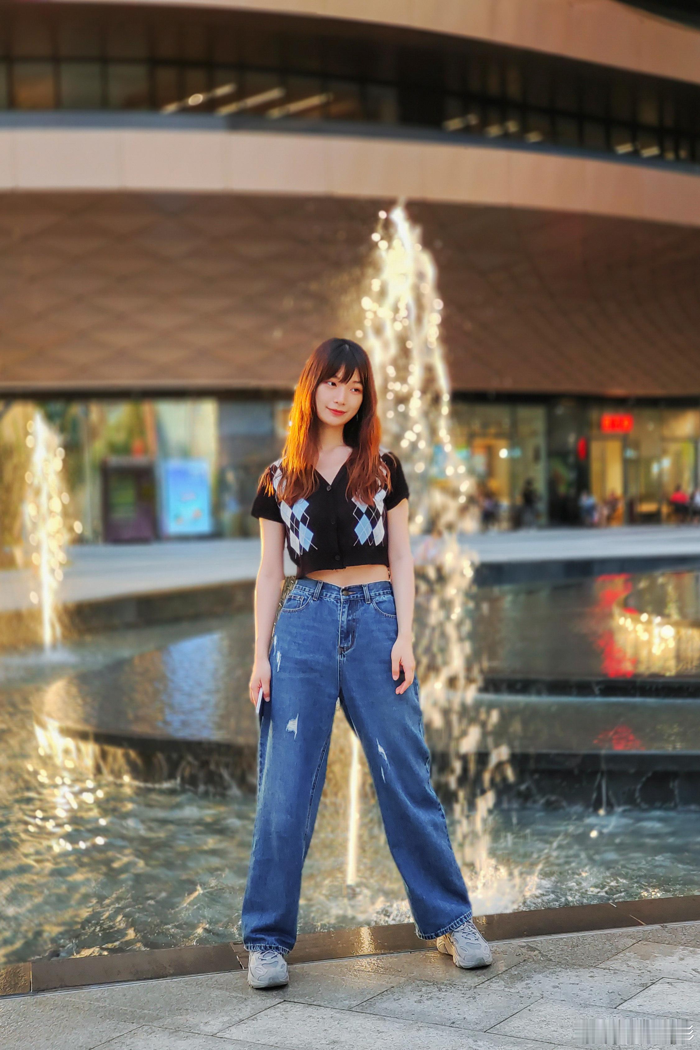 喷泉拍照氛围感拉满，喷泉光影里的温柔时刻～  在无限极广场，身穿蓝色牛仔裤发少女