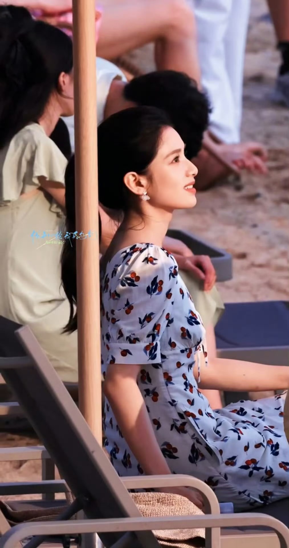 张婧仪海边人群中拍日落，想象中夏天扎高马尾的样子