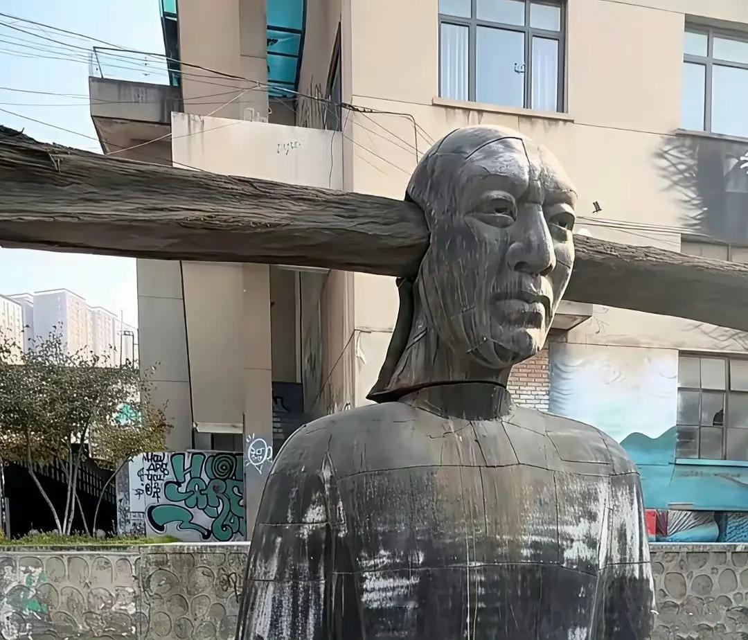 这座雕像的头部被一根木头横横的插入，让人看不明白，也让人不禁心生疑问，这种老百姓