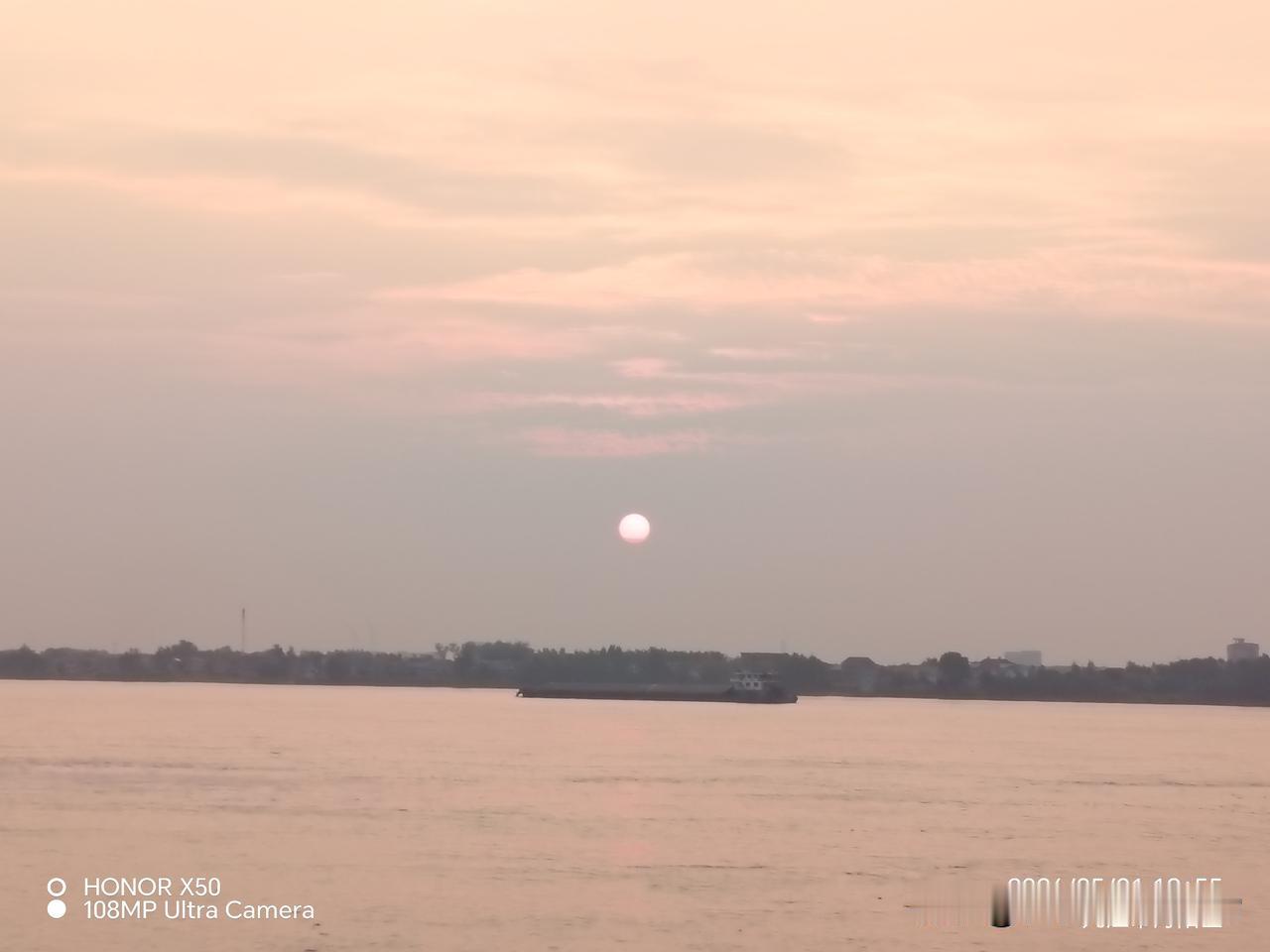 上头条召唤豆包 夕阳下的静谧河面，一艘船悠然驶过，心旷神怡。