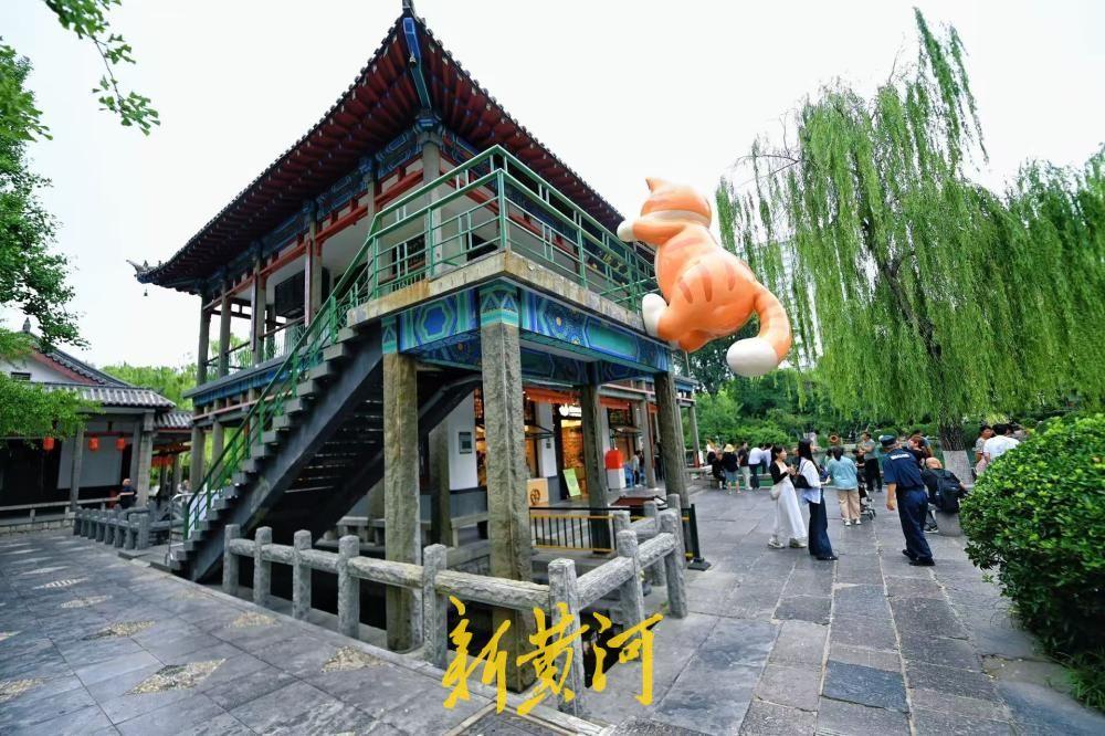 5月22日，在五龙潭名士阁二楼栏杆处，两只形态各异的橘猫雕塑正式亮相与游客见面，