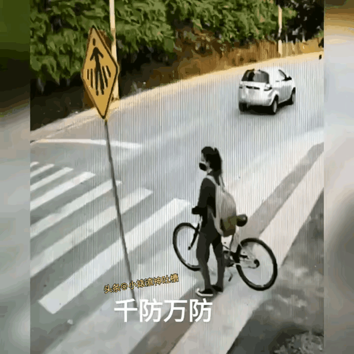 姑娘过斑马线推着车子，左顾右盼，时不时停下来让其他车辆先行。按说没有红绿灯的情况