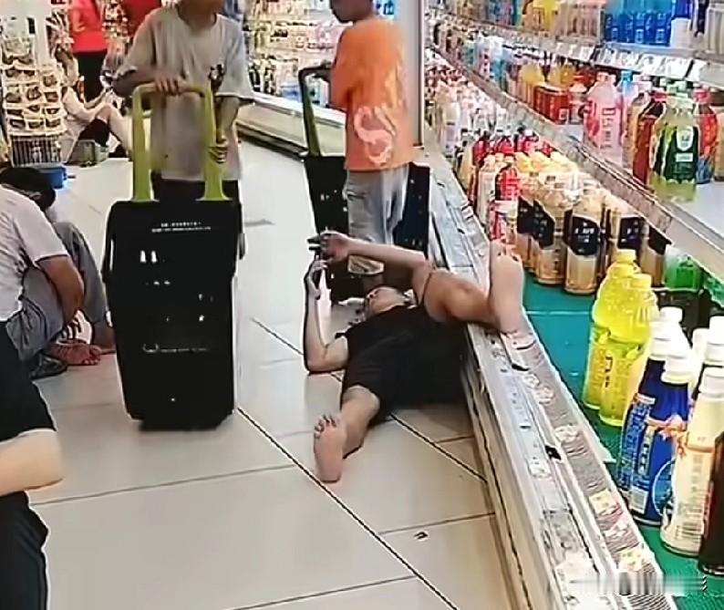 几个男人光着脚在坐在超市地上蹭空调，

看这场景，让不让人恶心。

其中一个男人