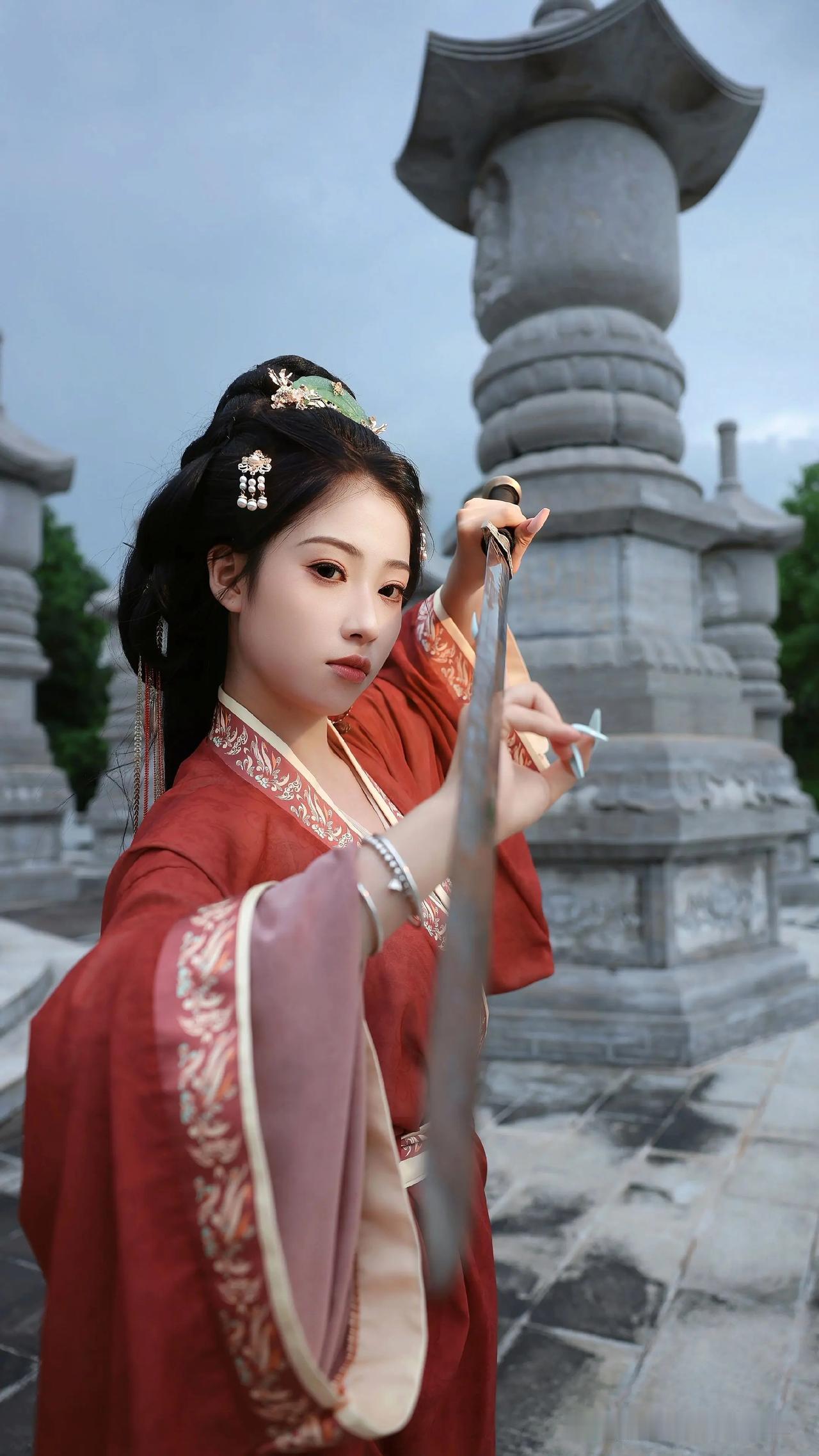 红衣侠女手执长剑，眼神清冷又俏皮。这江湖路远，且看美人如何一剑破风！国风美人持剑