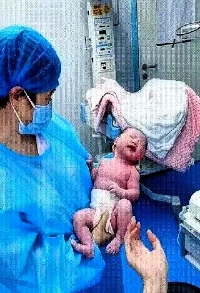 山东护士刚接完生，对着男婴轻轻一句“跟妈妈打个招呼”，小家伙居然伸手抓住她衣角，