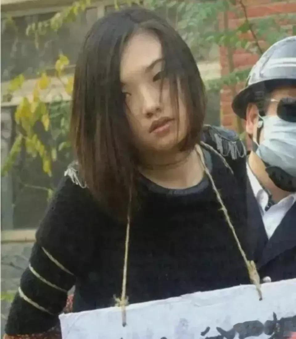 这张照片拍摄于上世纪80年代末，一个姑娘被五花大绑，由戴着钢盔的法警押解着，马上