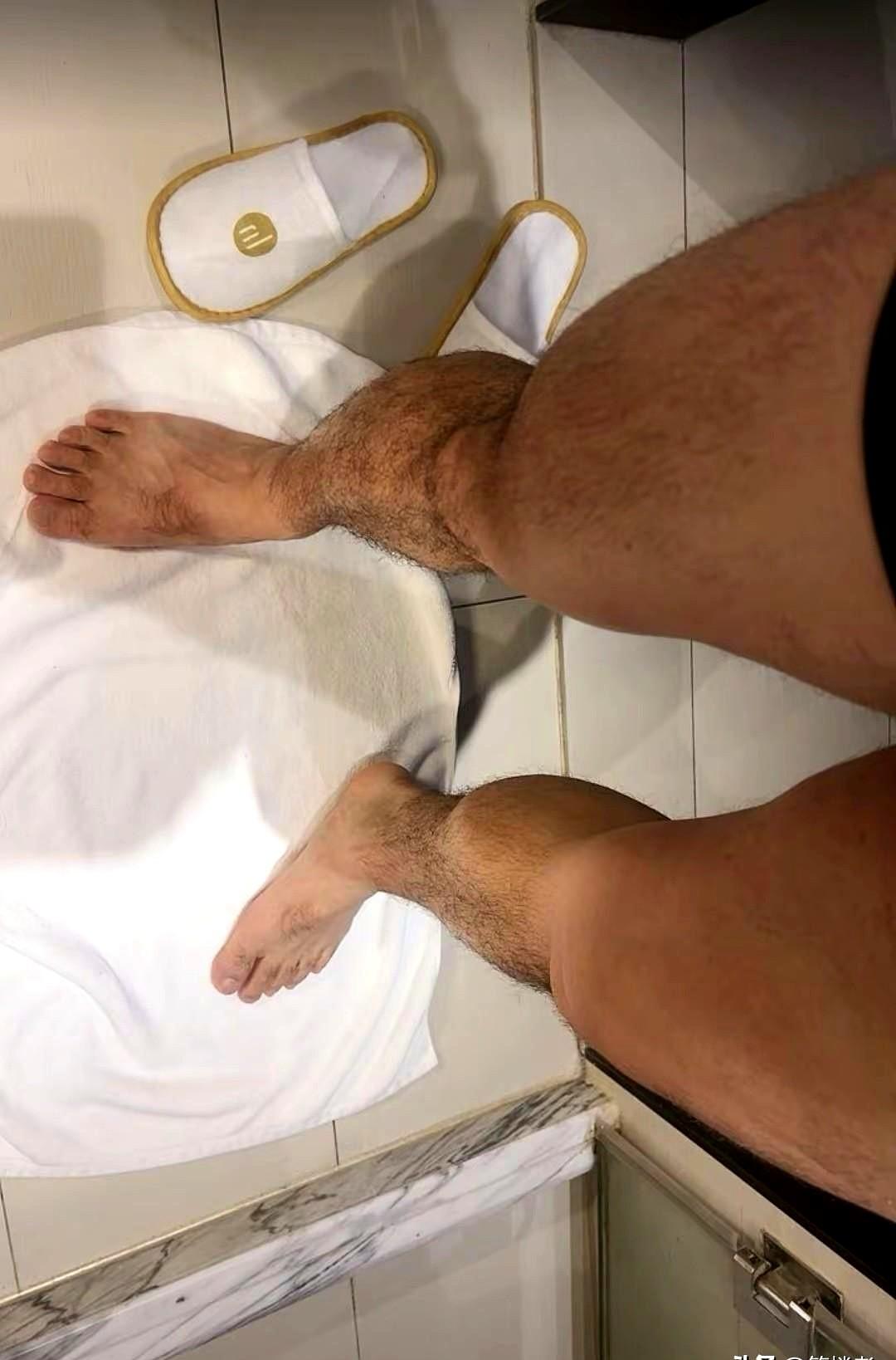 一个住宾馆的旅客，在酒店把毛巾摊在地砖上，然后光着脚丫站在上面。
热水壶里有人在