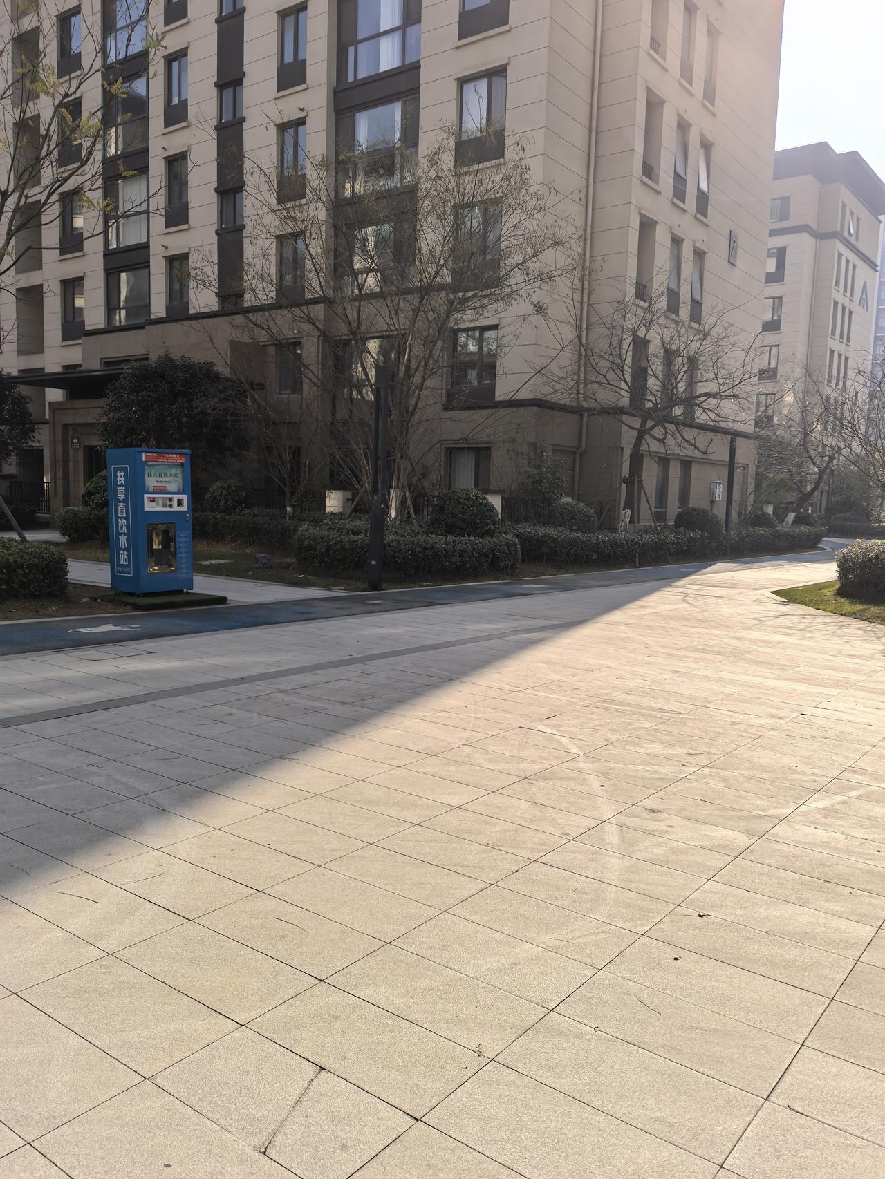 午后在小区里溜达，
阳光斜斜地洒下来，
把地砖晒得暖乎乎的～楼下的共享饮水机还立