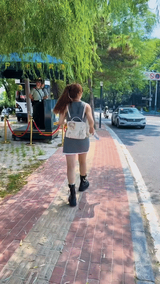 一名年轻女子给正在街头站岗执勤的战警战士送了两瓶水喝。
这样的行为真是看起来太暖