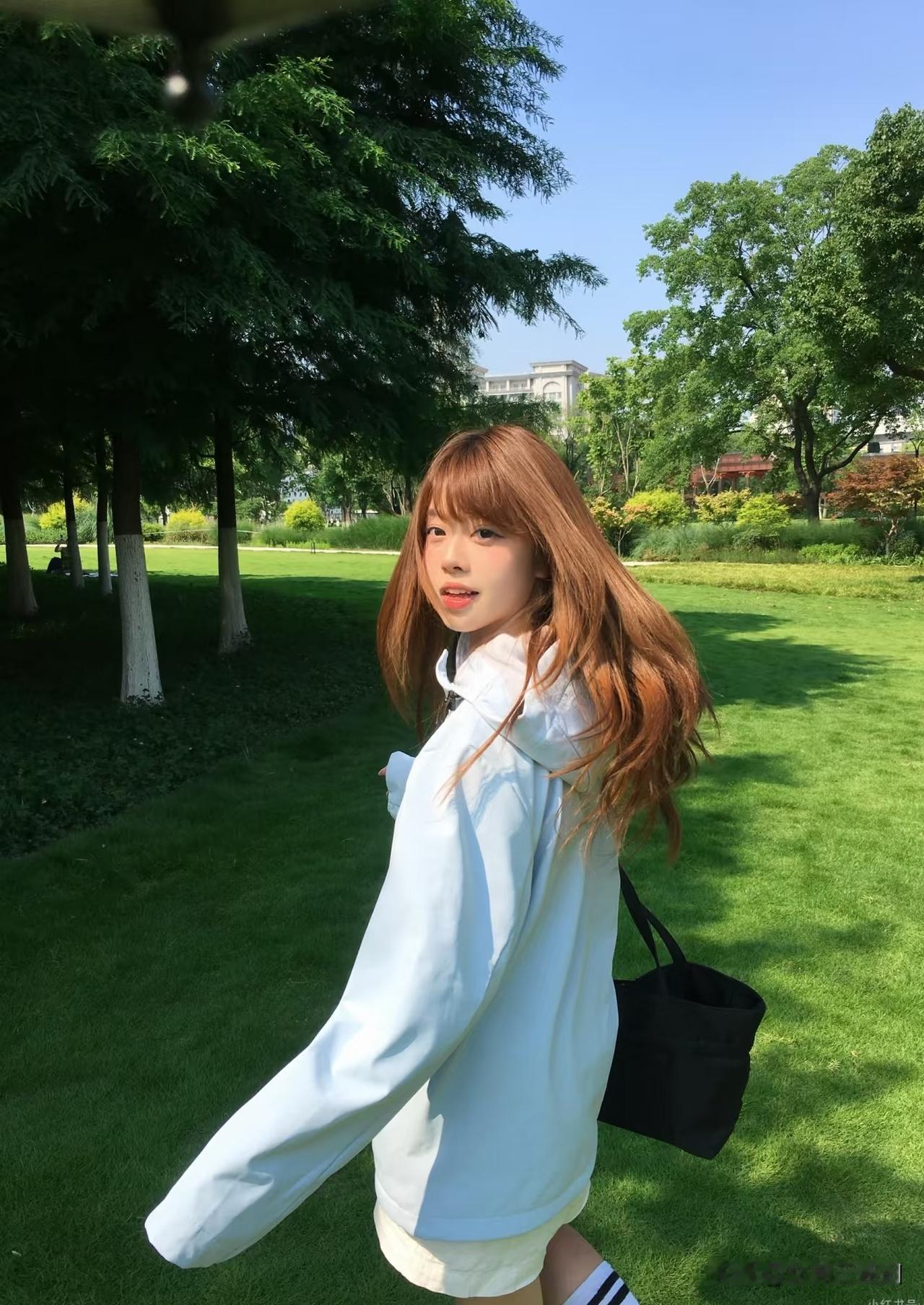 阳光明媚，女孩在公园散步。