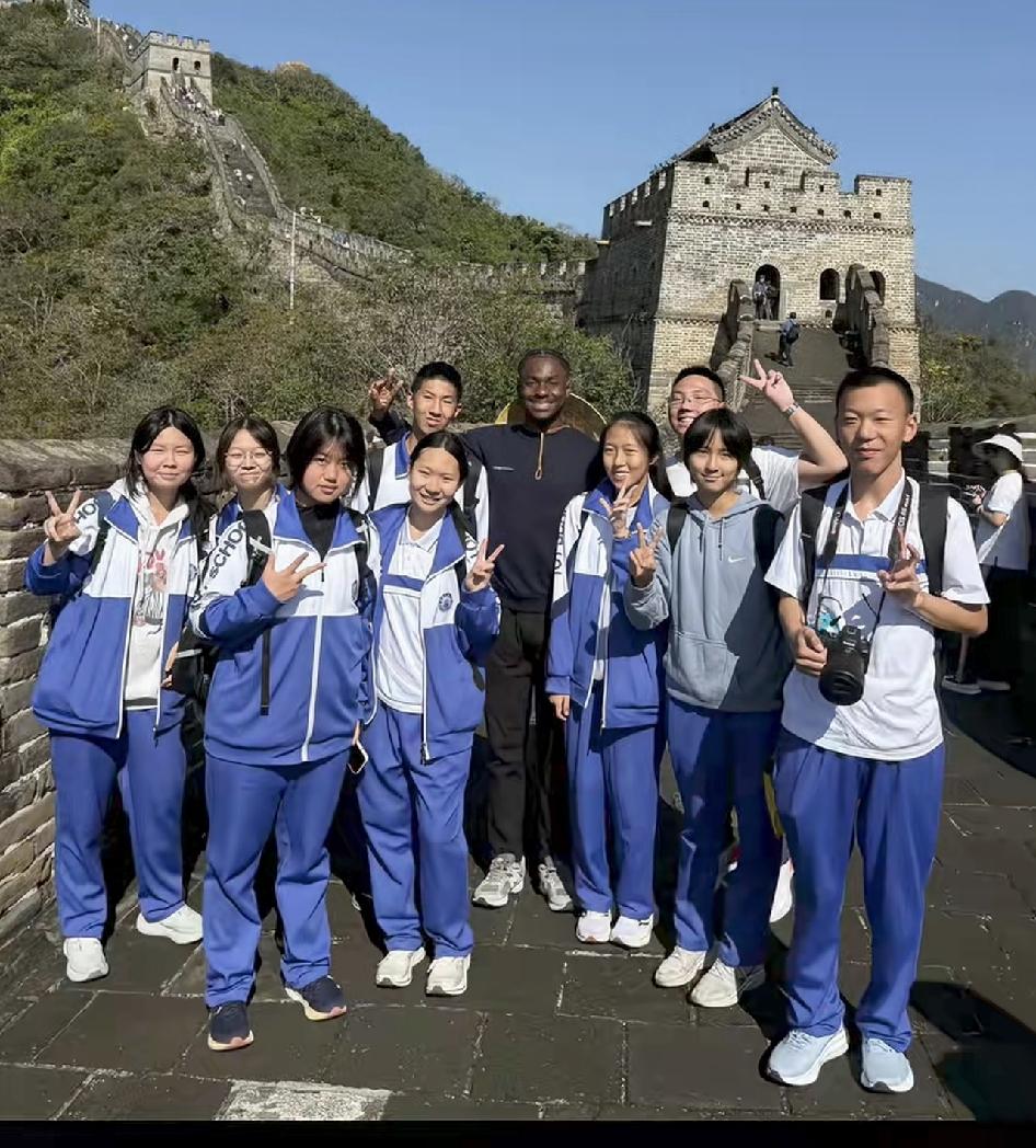 非洲小哥到长城旅游观光，受到中国人民的热情欢迎，被热情好客的祖国花朵团团围住。非