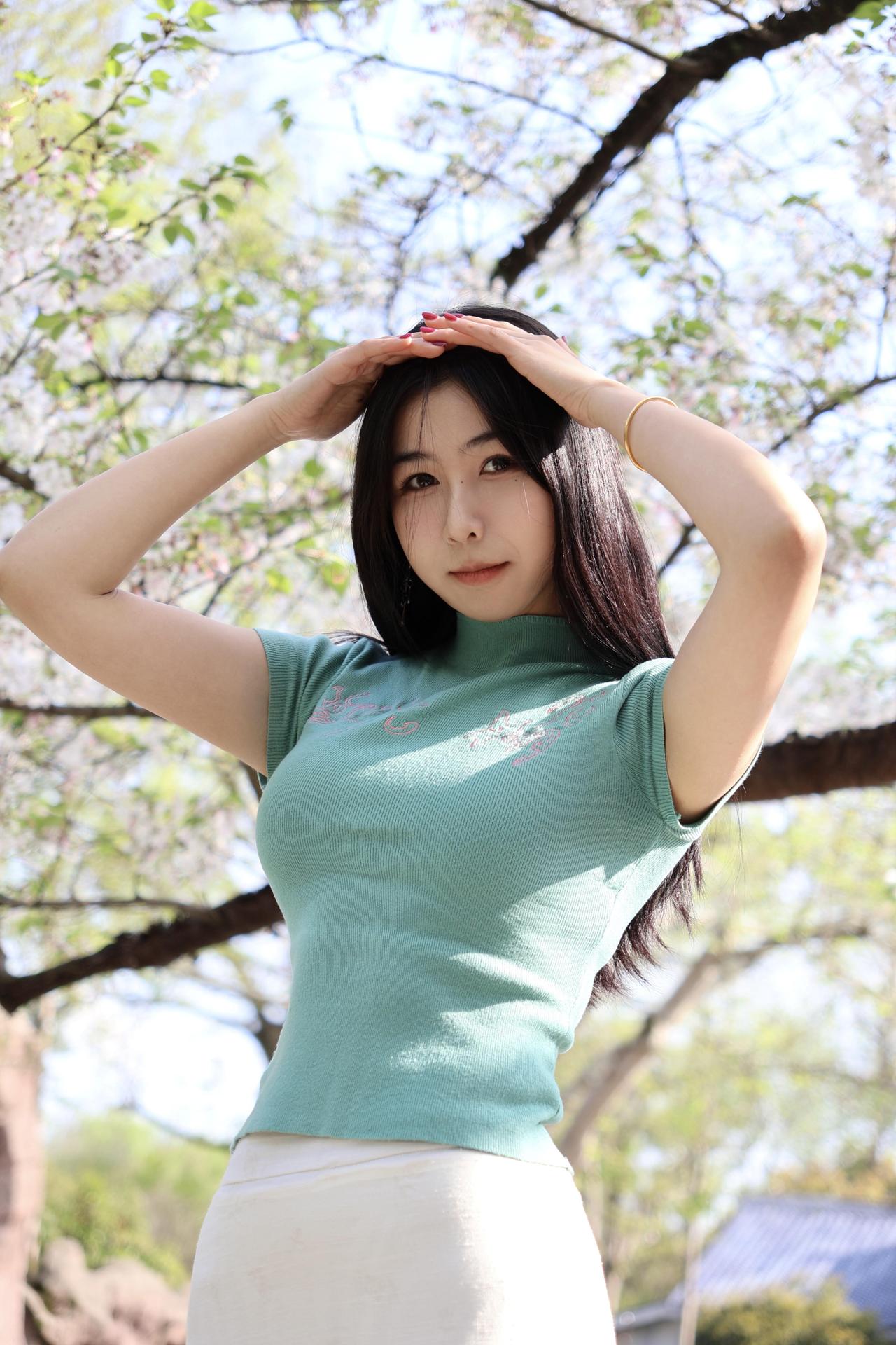 樱花树下，少女轻抚秀发，春意盎然。