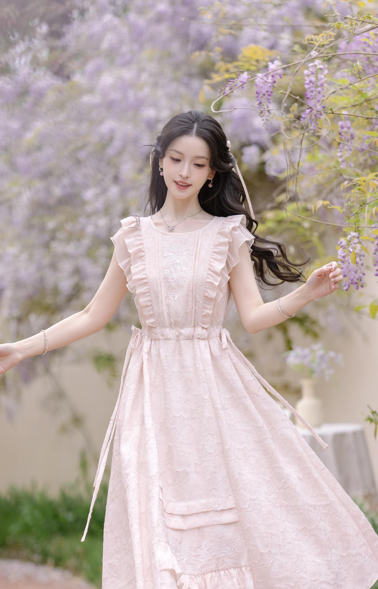 紫藤垂落，漫染一帘浅紫温柔。
一袭浅粉裙裾，轻赴春日的浪漫邀约。
风拂发丝，书页