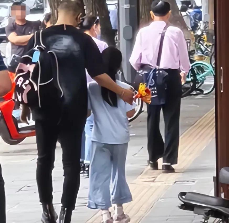 汪峰接女儿放学背影图
有人说，汪峰恋爱了不忘关心女儿
我想说，帮女儿背书包
这就