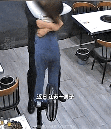 江苏，一对夫妻热情互动，丈夫一把将妻子搂入怀中。可拥抱之时，妻子立突然弯腰蹲在地