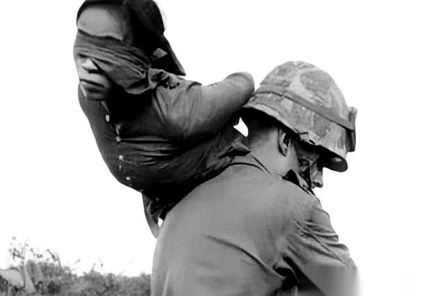 一张照片，就够了。
一个美国大兵，像扛一麻袋土豆一样，把一个蒙着眼的越南女兵甩在