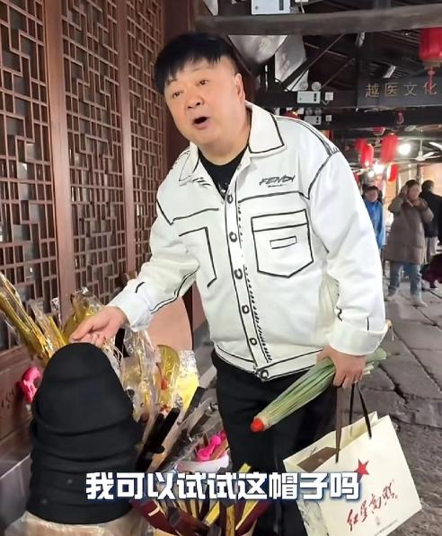 洪剑涛在浙江绍兴安昌古镇逛街时，看中了一个帽子想试戴一下，老板却说：“试一下5块