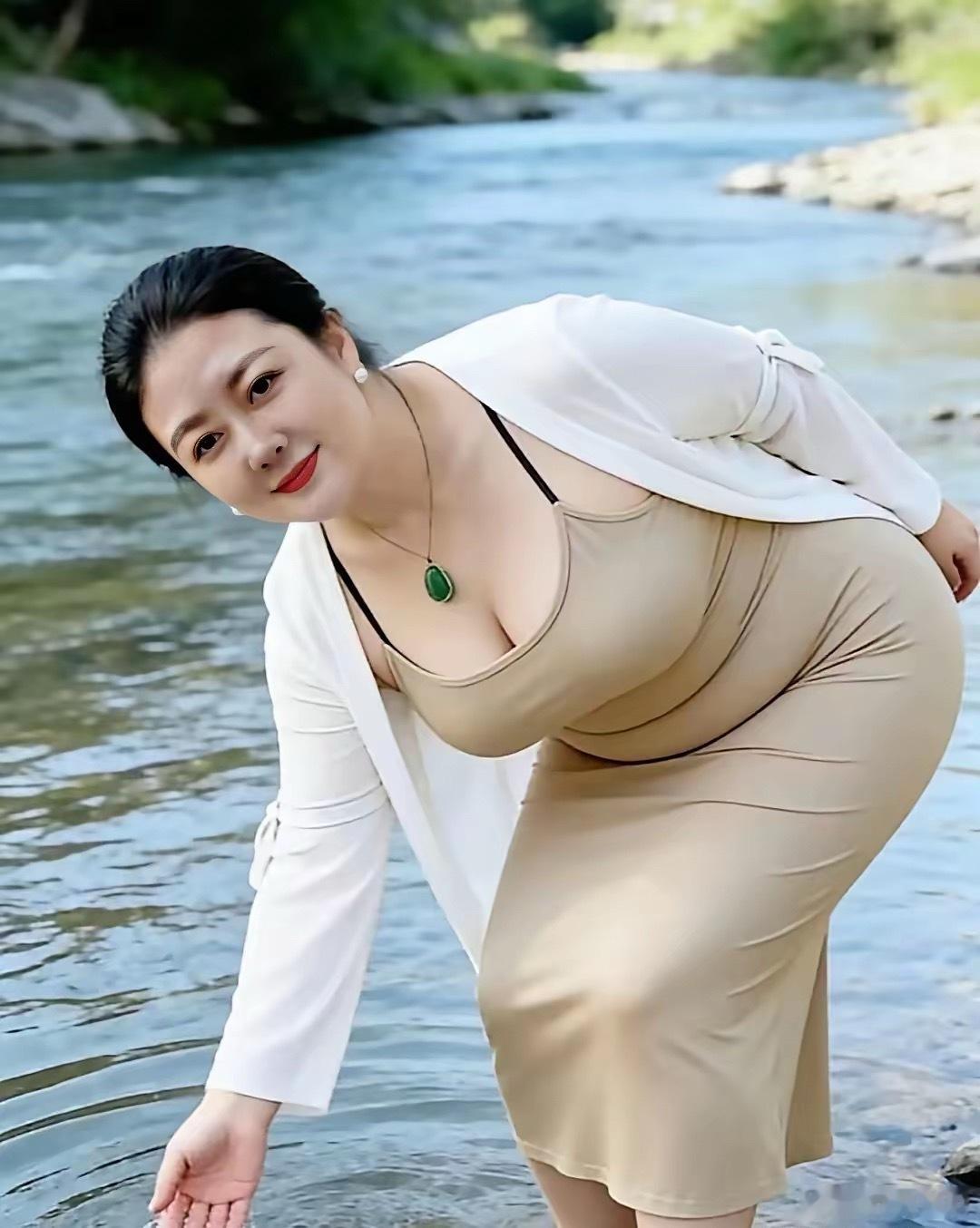 这位年轻漂亮的妈妈，在河边开心的戏水。她慈眉善目，造型优美，福报满满，一看就是一