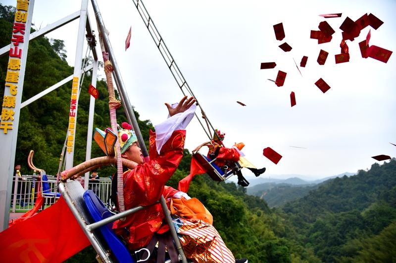 河南新乡八里沟景区玩得可太野了！景区财神演员吊着威亚在空中撒真钱，这画面直接在网