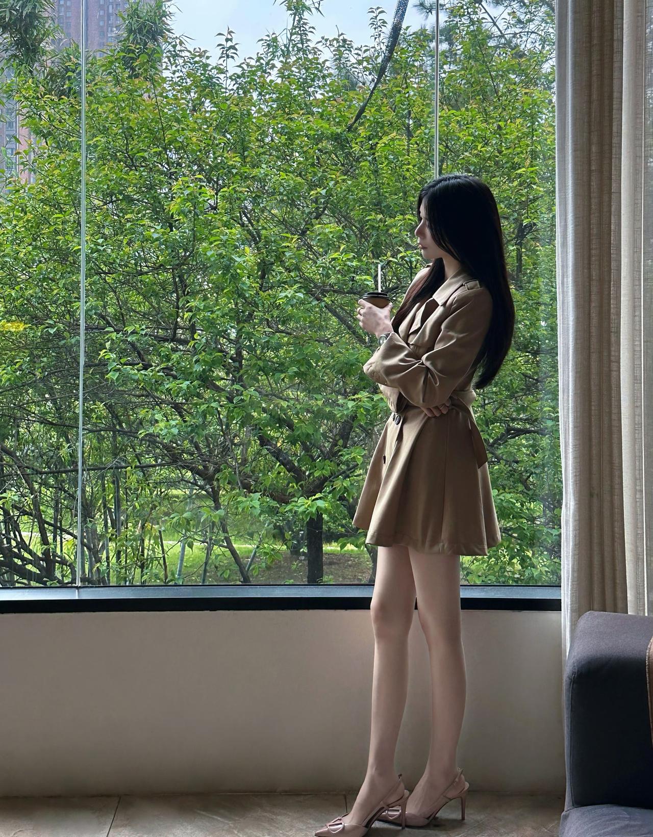 窗边的绿意和咖啡香，是松弛的周末时光。卡其色风衣裙裹着温柔，慢下来，享受独处的片
