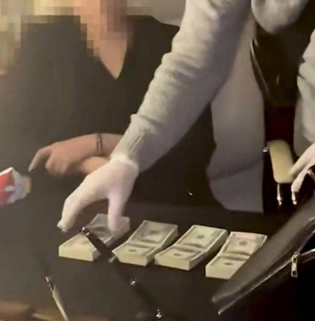 乌克兰国家安全局在对季莫申科办公室的搜查中，她的办公桌上明显放着几捆美元。据称3