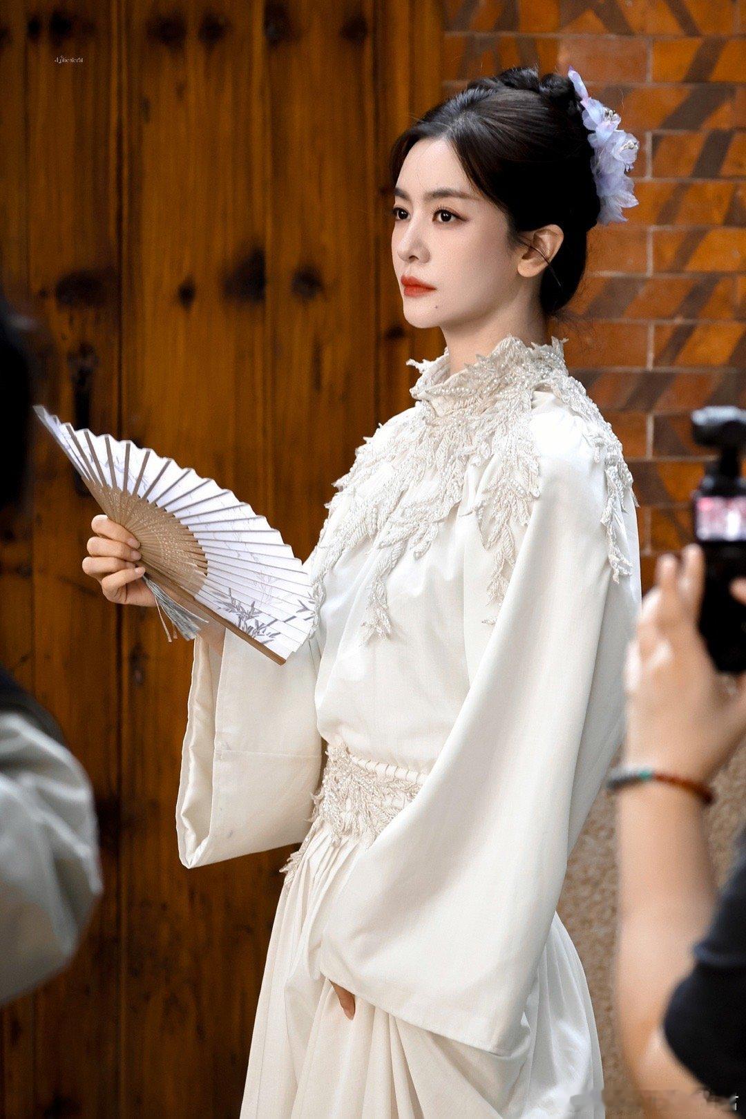 李晟簪的小小花李晟把泉州的小巷变成了她的个人秀场！丝绸白衣衬出优雅气质，小小簪花