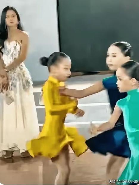 小小年纪就心术不正。深圳拉丁舞大赛中，黄裙子女孩正在投入舞蹈，蓝裙子女孩却从旁边