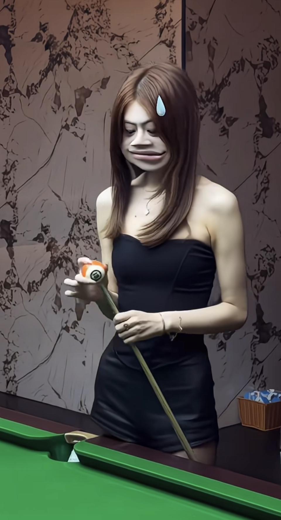 一个女孩在打台球，表情有点搞笑。