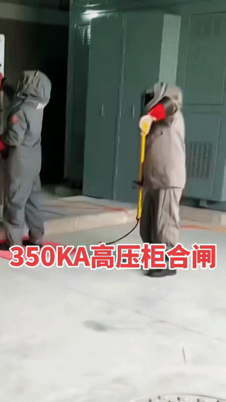 高压电柜合闸是一项非常危险的工作！
两名电力工人身穿全封闭的高压绝缘服进行高压电