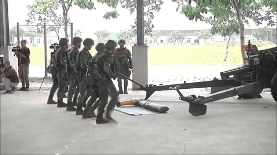 台军105毫米63甲榴弹炮的操炮演练，给自己壮胆打气。这门火炮的年龄与炮手爷爷的