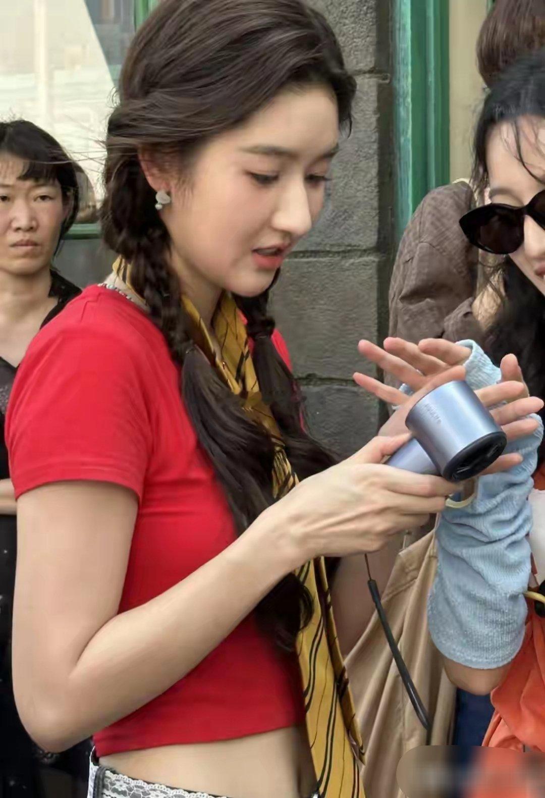 网友在环球影城偶遇王玉雯，梳着俏皮双马尾，穿红色上衣配迷彩中裤，脚踩红棕德训鞋，