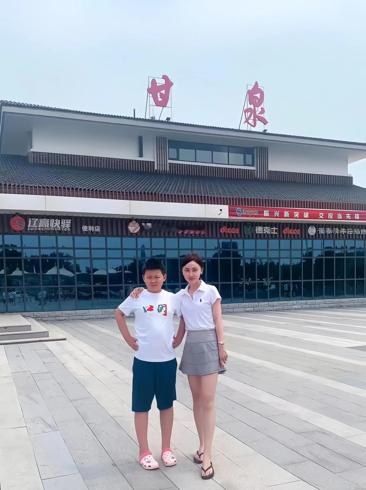 一位妈妈与儿子在甘泉车站前，拍下了难忘的合影。
妈妈看着好年轻啊。