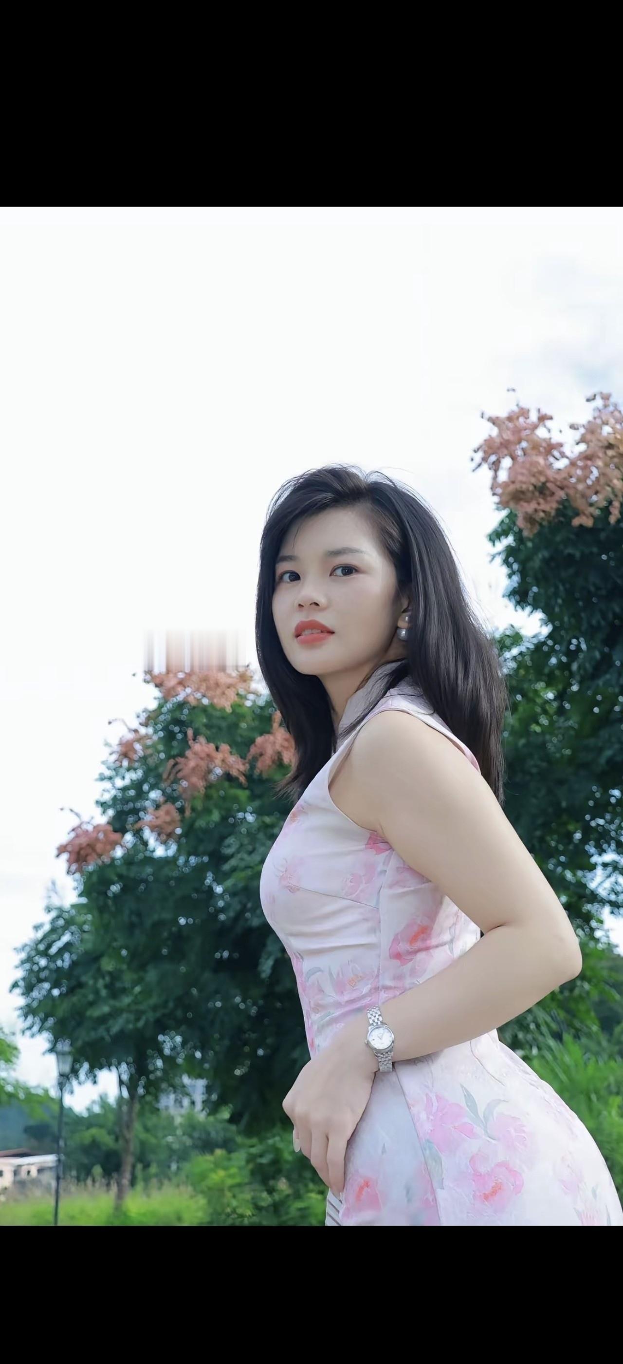 一个女孩站在花树旁，看着远方。
