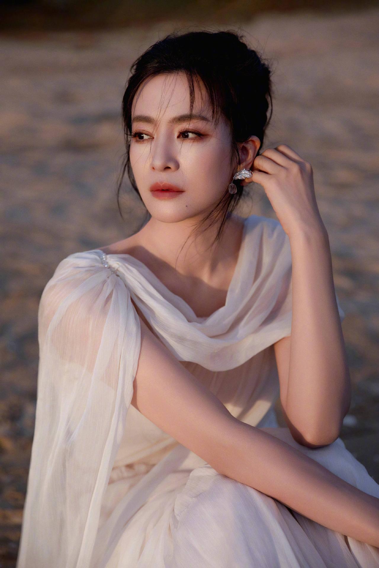 李晟一袭浅纱斜肩长裙惊艳亮相，轻盈纱质贴合身形，勾勒出曼妙有致的线条。恰到好处的