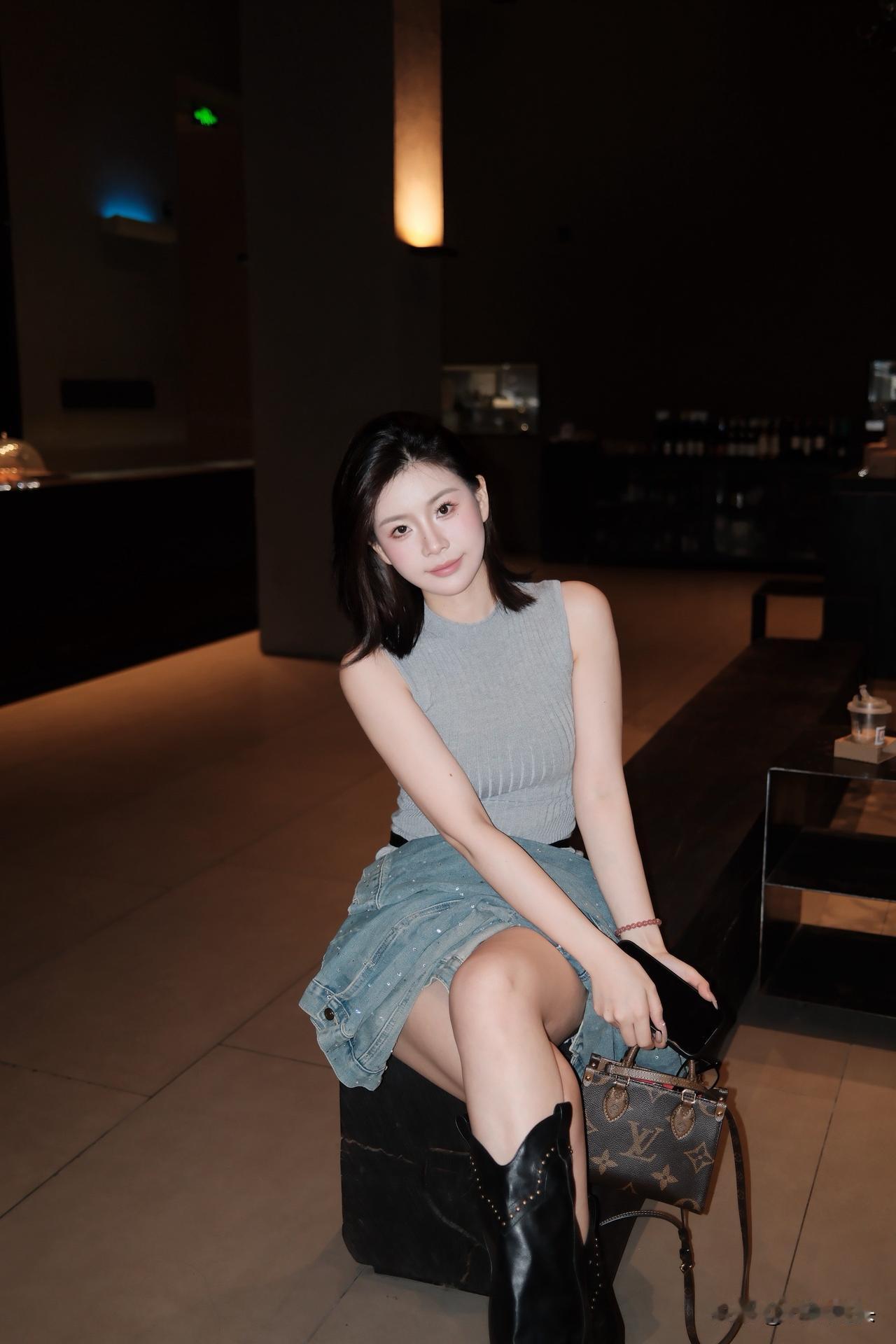 一个女孩坐在咖啡馆里，看着手机。