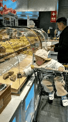 这位爸爸带着儿子到超市购物，在糕点区，爸爸正专心地挑选着……突然之间，坐在购物车