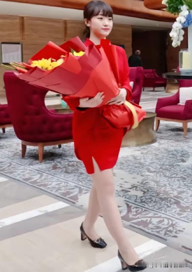 在机场欢迎仪式的聚光灯下，这位穿着红色连衣裙的女孩，她不是主角，却是最动人的风景