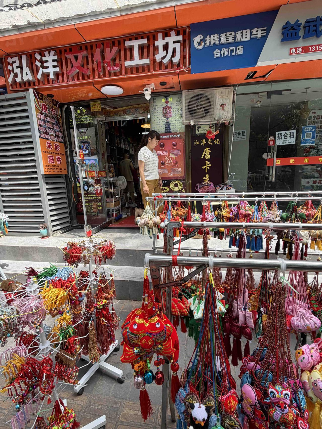 今天上午，我路过西安莲湖路，看到泓洋文化工坊门口，摆着三大架子香包，有大有小，造