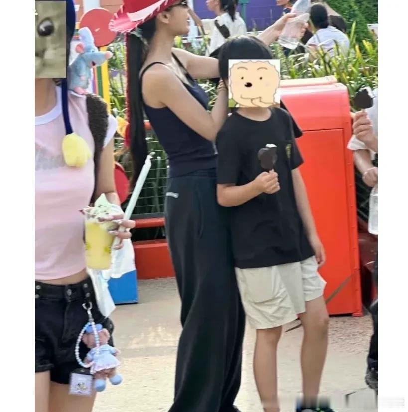 杨颖带9岁小海绵散步，三部手机跟着母子两一起等红灯，小海绵个头长的好快。 