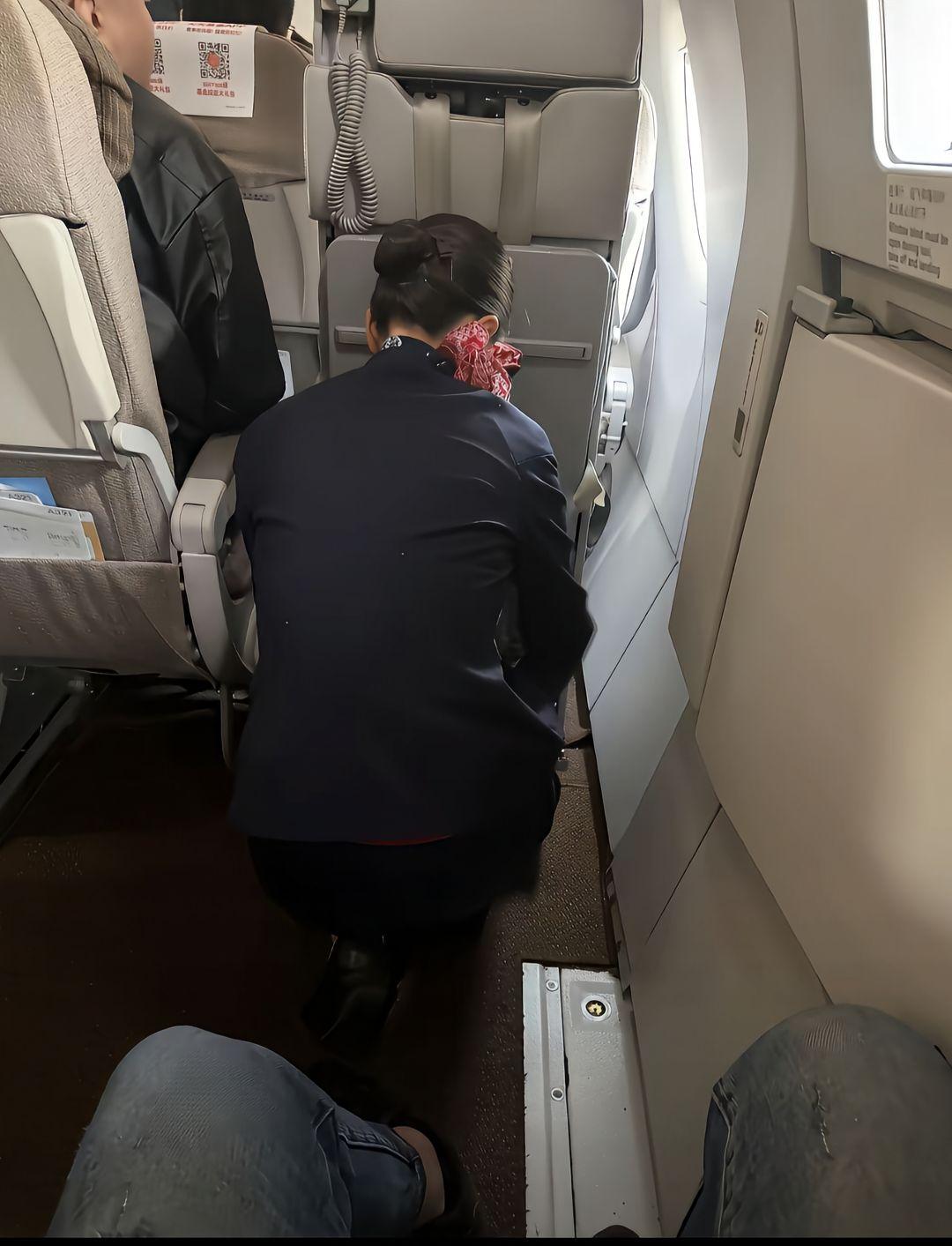 空姐弯腰整理行李，机舱内静谧舒适。
