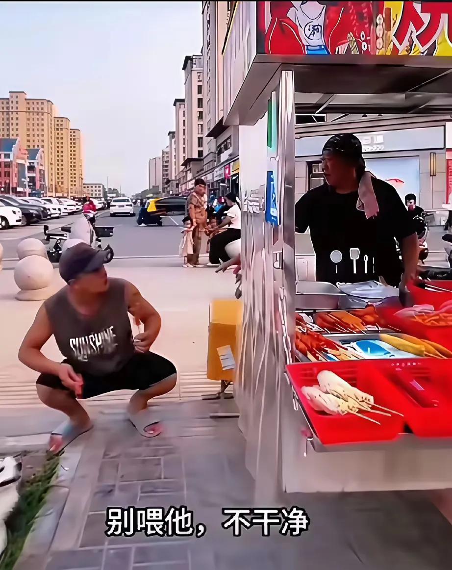 气笑了！有个小伙买了根烤肠，看见摊主的狗挺可爱，就想拿烤肠喂它，结果摊主一句话把