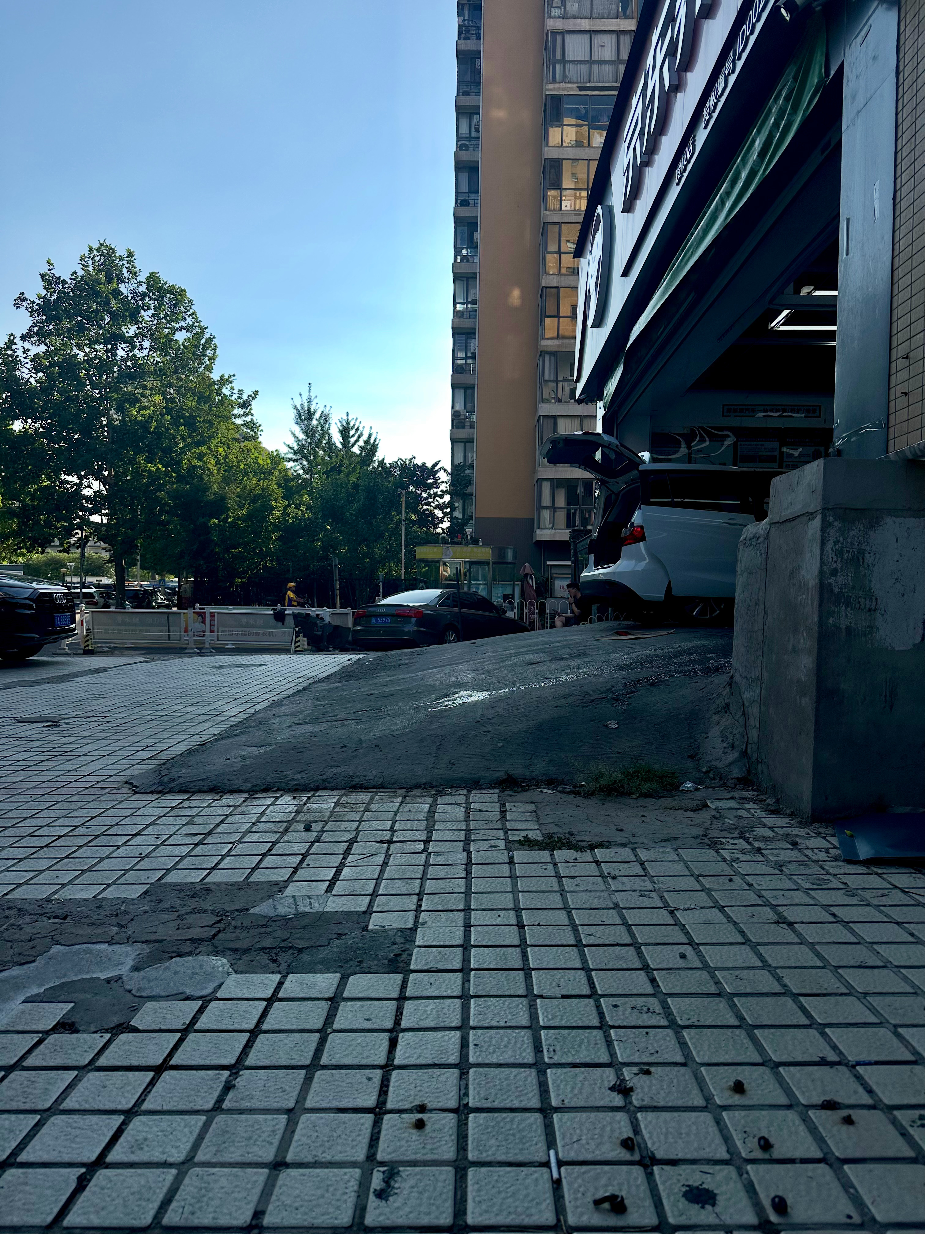 和这家京东养车店的师傅聊了下天，他说店门口这个坡度，一些底盘底的新能源轿车开上来