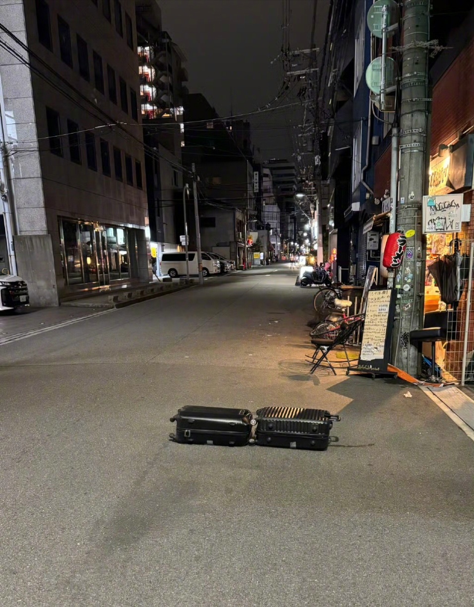 看到日本街头这张照片，我的第一反应，悬疑推理剧，有人半夜用行李箱抛尸街头…… 