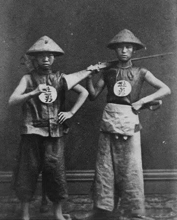 晚清时期，两名瘦小的清兵留影，照片中他们虽然使劲儿想要摆出一副“强悍”的姿态来，