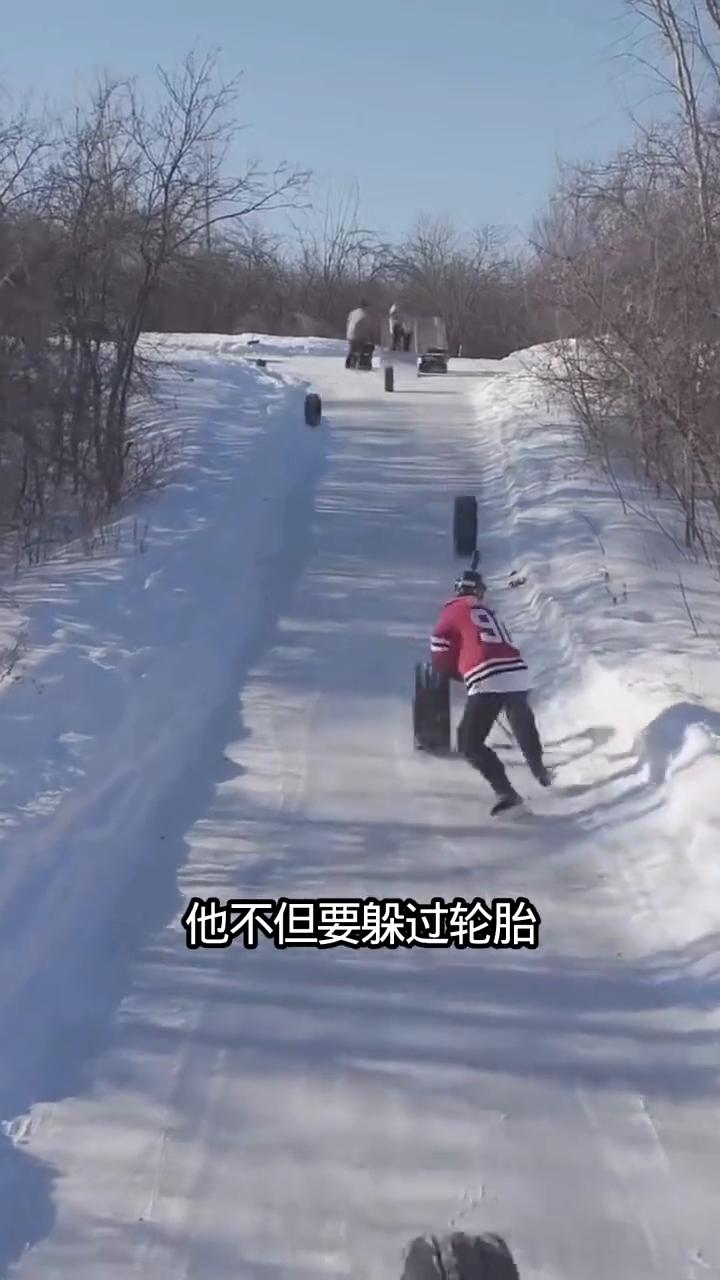 男子已经开始了他的挑战，不但要躲过轮胎的攻击，而且还要将冰球弄上去，难度可想而知